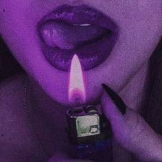 a woman holding a lighter in her mouth with the light on it's side