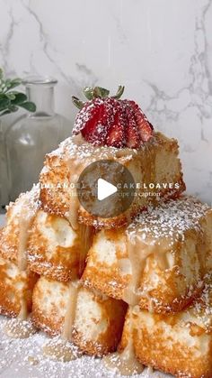 a stack of pastries covered in powdered sugar and topped with a strawberries