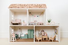 a doll house with furniture and accessories on the floor in front of a white wall