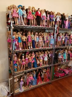 there are many barbie dolls on the shelves in this room and one is full of them