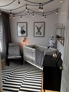 a baby's room with black and white striped rugs, pictures on the wall