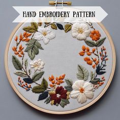 an embroidery pattern with flowers and leaves on it, in front of the words hand embroidery pattern