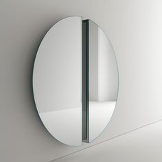 a white wall with a round mirror on it