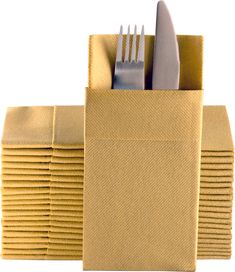 a stack of gold colored napkins with forks and knives in each pocket on white background