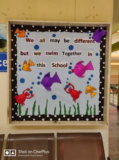 a bulletin board in the middle of a building with fish on it and words that read, we all may be different but we swim together in this school