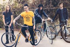 a group of young men riding bikes next to each other