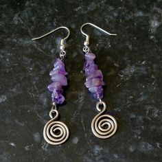 the earrings are made out of silver wire and amethorate beads with spiral design