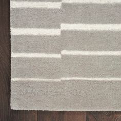 an area rug with white and gray stripes on it