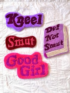 three different types of appliques on a white quilted bed spread with words that spell out good girl and do not smell