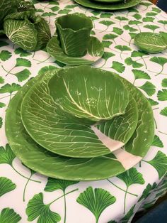 a table topped with green leafy plates and cups