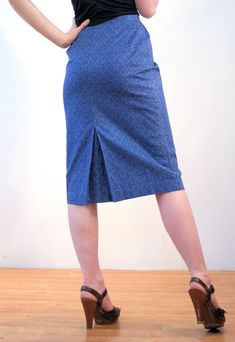 "This is a classic vintage 1960s blue paisley print pencil skirt. It features vertical pleats below the waistband, a center walking vent in the back, and a hem that ends just below the knee. It has a stylized, subtle floral paisley pattern, in turquoise green and navy blue on a deep blue background. The fabric is a sturdy cotton with a satin lining inside at the waist. The skirt closes with a button at the left hip and a 6 inch metal side zipper that is expertly placed, so that it is completely Retro Fitted Knee-length Skirt, Spring Retro Fitted Pencil Skirt, Retro Fitted Pencil Skirt For Spring, Vintage Fitted Knee-length Pencil Skirt, Retro Fitted Knee-length Pencil Skirt, Vintage Fitted Midi Skirt, Retro Fitted Lined Pencil Skirt, Vintage Blue Skirt For Work, Retro Fitted Midi Skirt