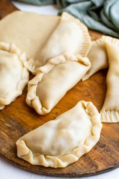 several pastries are sitting on a wooden platter and ready to be eaten,