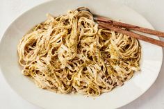 a white plate topped with pasta and two wooden spoons