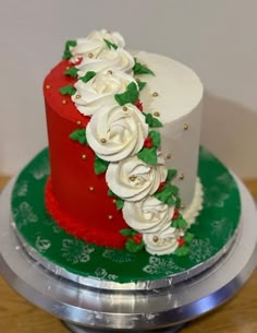 there is a red and white cake with flowers on the top, sitting on a green plate