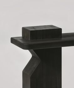 a black object is sitting on top of a wooden table and it appears to be made out of wood