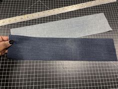 someone is cutting up some fabric on top of a piece of cloth with a ruler