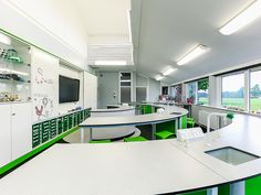 an empty laboratory with green and white counter tops in front of a large screen tv