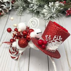 a red and white hat with snowflakes on it sitting next to christmas decorations