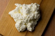 a wooden cutting board topped with cauliflower on top of a table