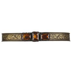 Vintage Victorian Revival c.1930's bronze floral metal mesh belt. Bronze-tone metal mesh belt has a floral design imprinted on mesh. Buckle is made of three large faceted prong set amber colored stones set in ornate bronze carved settings. Two stones are set horizontally on either side of the vertically set center stone (measuring 1"L x 3/4" W each). Jewels are set on a loop and hook buckle. Piece is unmarked. A single grommet has been replaced. Measurements: Total length: 31.5" Body of Belt Wid Jeweled Belts, Floral Belt, Belt Hook, Victorian Revival, Belt Brown, Large Hole Beads, Brown Belt, Vintage Belts, Metal Mesh