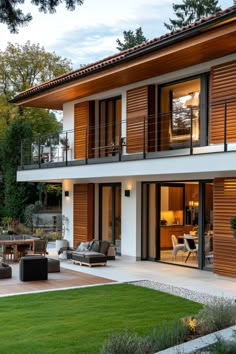 a modern house with wooden shutters and outdoor furniture