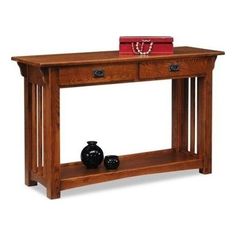 a wooden table with two drawers and a red purse on it's top shelf