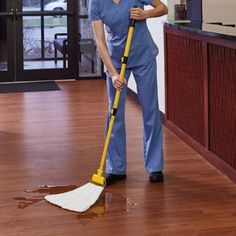 a woman cleaning the floor with a mop