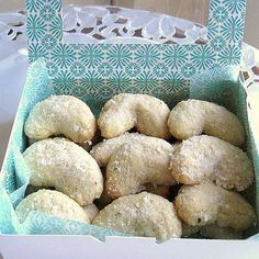 a box filled with powdered sugar donuts on top of a white tablecloth