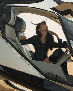 a woman sitting in the driver's seat of a jet airplane looking up at the sky