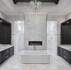 a large bathroom with two sinks and a bathtub in the middle of the room