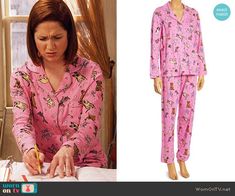 the woman is wearing pink pajamas and writing