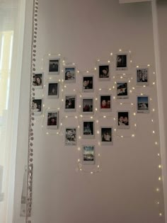 a white wall with pictures on it and string lights strung across the entire wall above