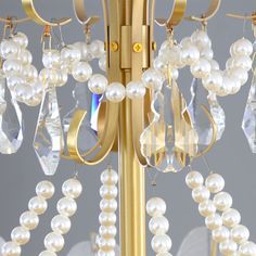 a chandelier with pearls hanging from it's sides