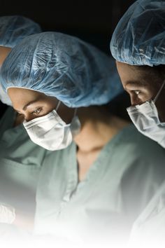 two surgeons in scrubs are looking at something