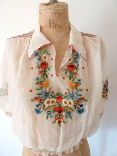 a white blouse with colorful flowers on it