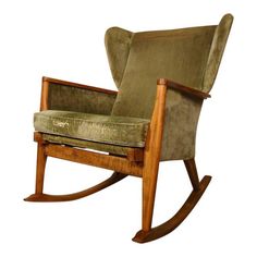 a wooden rocking chair with a green upholstered seat and back cushion on an isolated white background