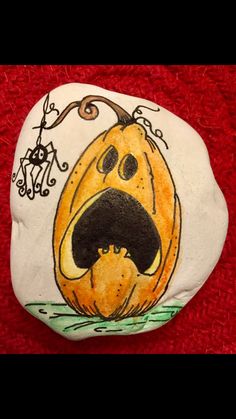 a painted rock with an image of a pumpkin on it's face and mouth