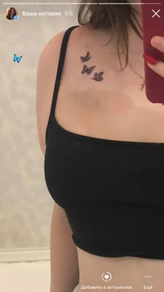 a woman with a tattoo on her chest holding a cell phone in front of her