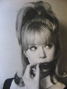 a black and white photo of a woman with her hand on her chin