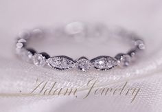 a close up view of a wedding ring on a white cloth with the word always jewelry written below it