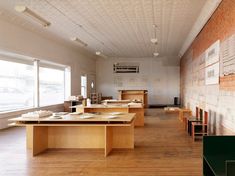 an empty room with wooden tables and chairs