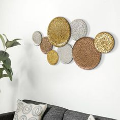 a living room with a gray couch and some gold and silver circles on the wall