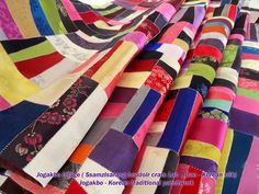 many different colored fabrics are stacked on top of each other, with the same pattern