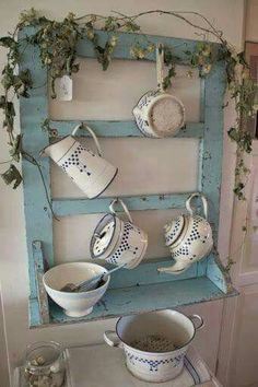 tea cups and saucers are displayed on an old window frame