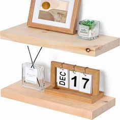 two wooden shelves with calendars on each shelf and an empty glass bottle next to them