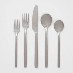 five forks, two spoons and one knife on a white surface