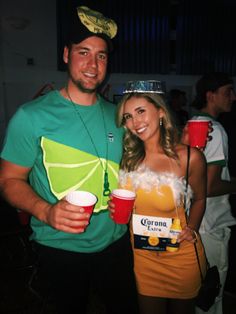 a man and woman dressed up in costumes at a party with cups on their heads