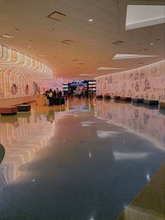 people are walking through an airport lobby with large mirrors on the walls and flooring