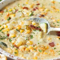 a white bowl filled with corn chowee and topped with a ladle full of soup