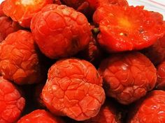 a pile of red raspberries sitting on top of a white plate